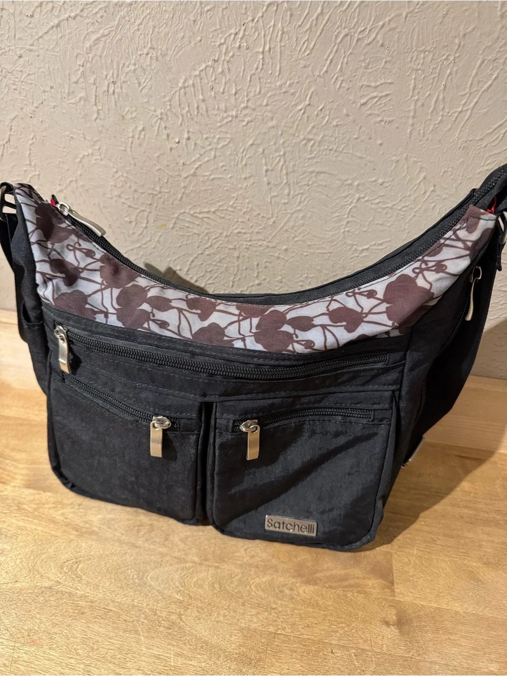 Satchelli Black Crossbody Bag with Floral Accent and Red Lining